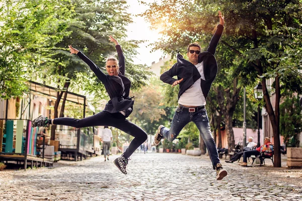 Atraktivní žena a pohledný muž, skákání na ulici — Stock fotografie