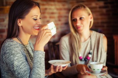 İki genç kadın arkadaş barda dedikodu