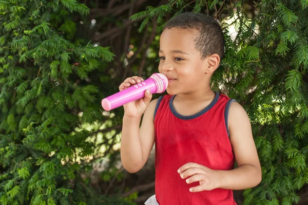 Söt liten sångarepojke sjunger på mikrofonen i staden par — Stockfoto
