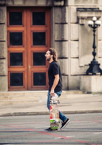 Skateboarder cruzando estrada nas ruas da capital — Fotografia de Stock