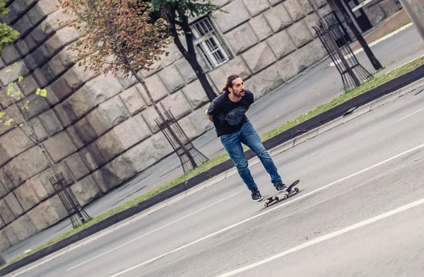 De helling van een skateboard rijden op de straten van de stad skateboarder — Stockfoto