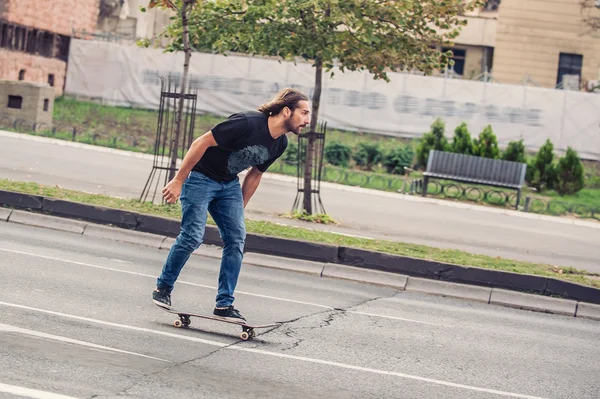 Skater jazda na zboczu deskorolka na ulicach miasta — Zdjęcie stockowe