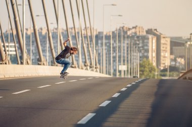 Kaykaycı bir kaykay sürme ve yol köprüsünde atlar yapıyor