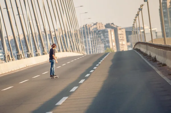 Скейтбордист катался на скейте по городскому автодорожному мосту — стоковое фото