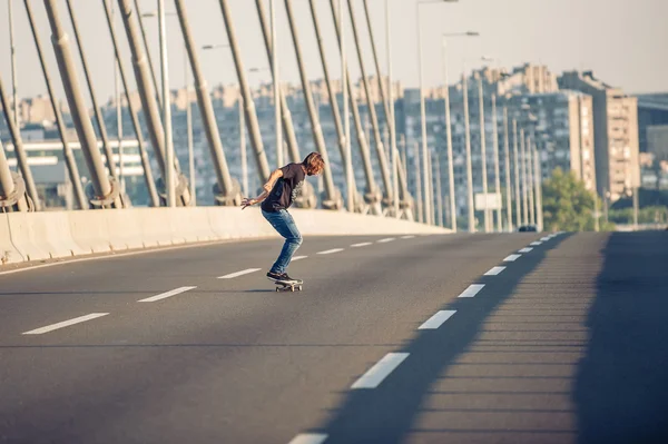 Skateboarder ιππασίας ένα πατίνι πάνω από μια γέφυρα δρόμο πόλης — Φωτογραφία Αρχείου