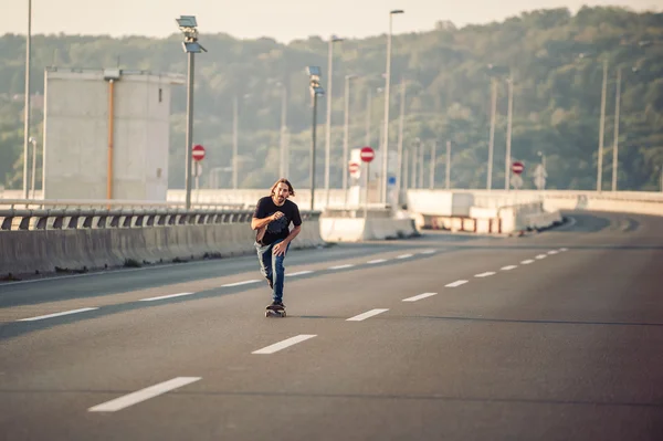 Skateboarder riding a skate over a city road bridge — Stock Photo, Image