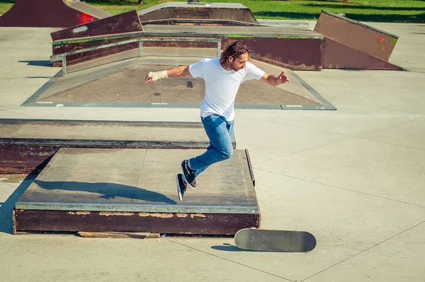 Jovem andando de skate no parque e caindo — Fotografia de Stock