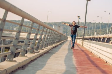 Kaykaycı bir şehir köprüsünün üzerinden kayıyor. Ücretsiz binmek kaykay