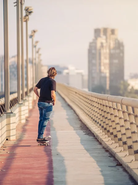 Skateboardista se brusle nad městským mostem. Volný výlet skateboardingu — Stock fotografie