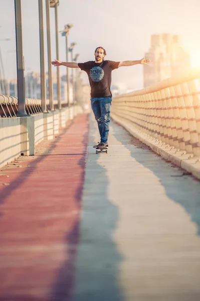 Ο σκέιτμπορντ κάνει πατινάζ σε μια γέφυρα της πόλης. Δωρεάν βόλτα με σκέιτμπορντ — Φωτογραφία Αρχείου