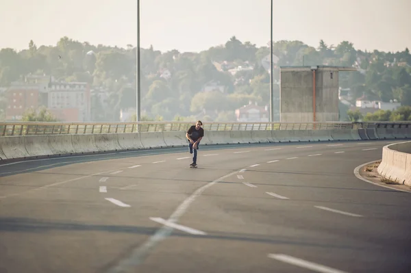 Скейтбордист катался на скейте по городскому автодорожному мосту — стоковое фото