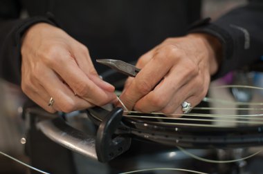 Close up of tennis stringer hands doing racket stringing clipart