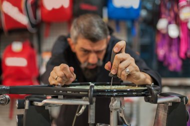 Tığ tutarak ve raket çekimi yapıyor Tenis stringer
