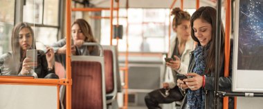 Genç kız şehir otobüsünde bir cep telefonu kullanır. Teknoloji cep telefonu izolasyonu. İnternet ve sosyal medya