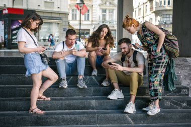 Group of friends using smartphones together. Young people addiction to new technology trends. Youth, new generation internet friendship concept. Emotional isolation and depresion clipart