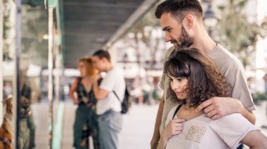 Alışveriş merkezindeki bir grup insan bir butiğin vitrininde yeni moda giysiler arıyor. Dükkan satışları. Kara Cuma konsepti