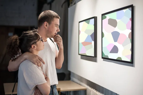 現代美術展ギャラリーホールでの若いカップルは アートワークを検討する 抽象画 — ストック写真