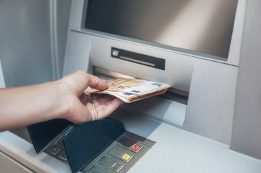 Woman hand taking money from bank cash ATM machine. Close up. Cash point. Finance, transactions, credit card, money withdraw, currency concept