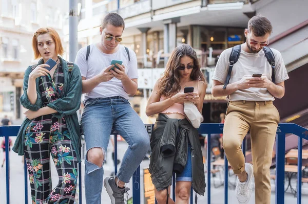 Akıllı telefonları birlikte kullanan bir grup arkadaş. Gençler yeni teknoloji eğilimlerine bağımlı. Gençlik, yeni nesil internet arkadaşlık kavramı. Duygusal izolasyon ve küçümseme