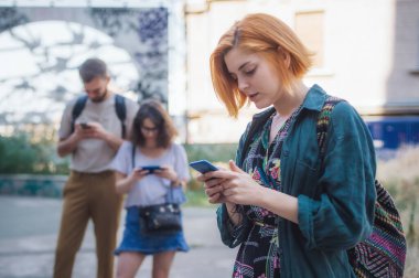 Akıllı telefonları birlikte kullanan bir grup arkadaş. Gençler yeni teknoloji eğilimlerine bağımlı. Gençlik, yeni nesil internet arkadaşlık kavramı. Duygusal izolasyon ve küçümseme