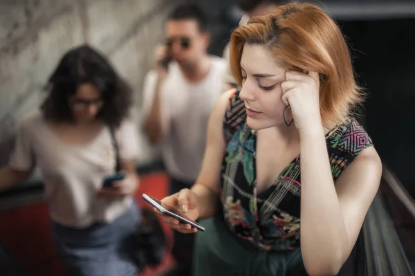 Bir Grup Arkadaş Yürüyen Merdivende Dururken Akıllı Telefonlardan Konuşur Dışarıda — Stok fotoğraf