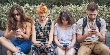 Yabancılaşma bağımlılığı. Akıllı telefonları birlikte kullanan bir grup arkadaş. Gençler yeni teknoloji eğilimlerine bağımlı. Gençlik, yeni nesil internet arkadaşlık kavramı. Duygusal izolasyon ve küçümseme