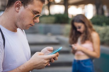 Yabancılaşma bağımlılığı. Akıllı telefonları birlikte kullanan bir grup arkadaş. Gençler yeni teknoloji eğilimlerine bağımlı. Gençlik, yeni nesil internet arkadaşlık kavramı. Duygusal izolasyon ve küçümseme