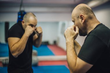 Dövüş antrenmanı ve dövüş tekniği gösterisi. Dojo salonunda saldırgana karşı. Dövüş sanatları pratiği