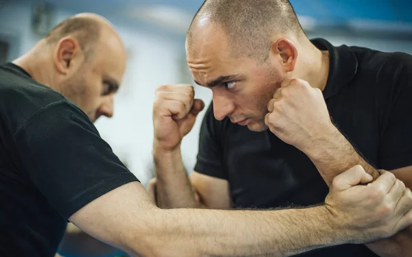 Sparring training and demonstration of street fight technique against attacker in dojo gym. Martial arts practice