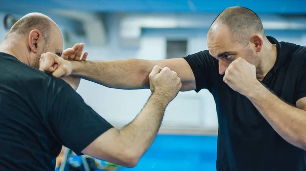 Sparring training and demonstration of street fight technique against attacker in dojo gym. Martial arts practice