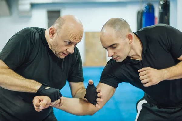 Sparring training and demonstration of street fight technique against attacker in dojo gym. Martial arts practice