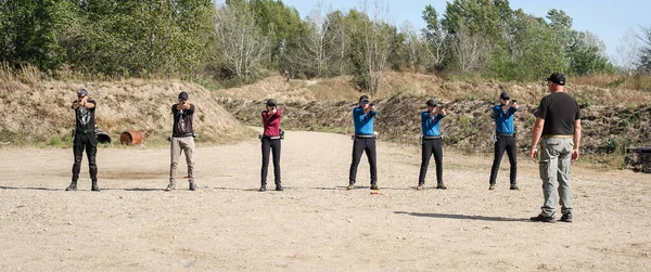 在射击场训练操作和射击的学生小组 — 图库照片