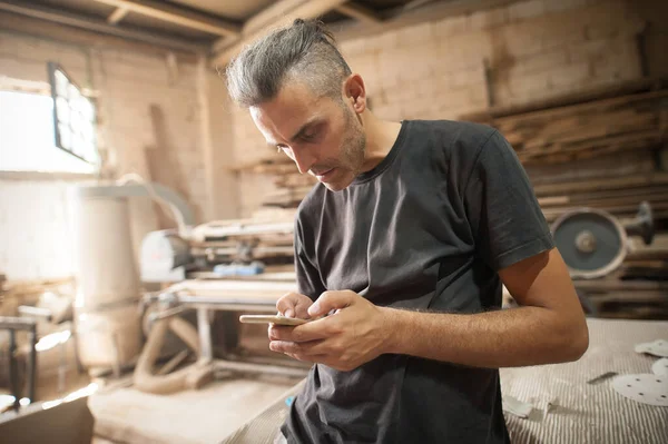 Carpinteiro Artesão Descansando Oficina Rolando Smartphone Handsome Handicraftsman Mensagem Texto — Fotografia de Stock