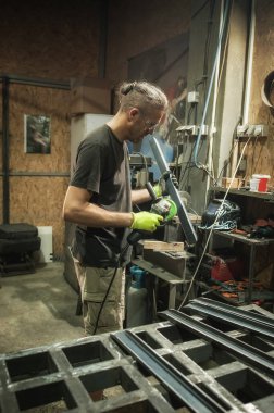 Fabrikadaki çelik yapı üzerinde çalışan bir zanaatkar. Metal işçiliği üretimi