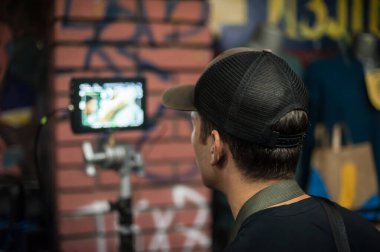 Sahne arkasında. Film yönetmeni, açık hava film montaj stüdyosundaki LCD panelinde filmin çekimini denetler ve kontrol eder. Analog ve dijital video düzenleme