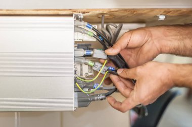 Elektrik mühendisinin kapağı elektrik kablolarıyla çalışıyor. Kurulum denetimi. Elektrik ekipmanları