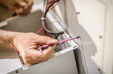 Elektrik mühendisinin kapağı elektrik kablolarıyla çalışıyor. Kurulum denetimi. Elektrik ekipmanları