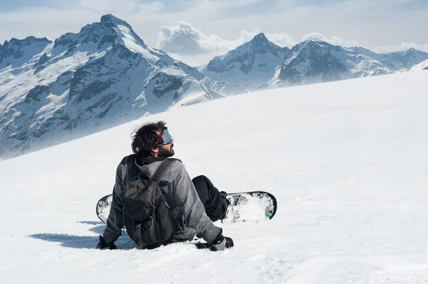 Snowboarder sentarse en la cima de la montaña —  Fotos de Stock