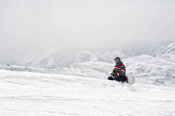 Сноубордист сидить на вершині гори — стокове фото