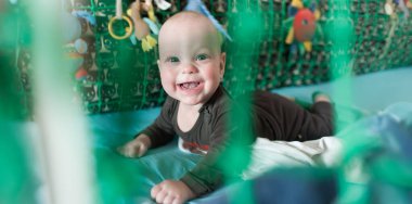 Neşeli bir bebek renkli oyuncaklar arasında yumuşak battaniyeler üzerinde mutlu bir şekilde emekler. Oyun alanı parlak dokular ve neşeli seslerle dolu. Keşif için hoş bir atmosfer yaratıyor..