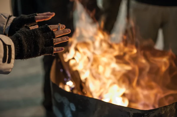 Bezdomny człowiek ocieplenie jego ręce przez pożar — Zdjęcie stockowe