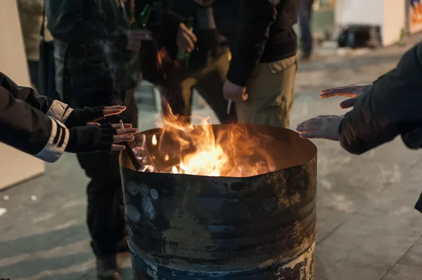 Evsiz adam ellerini ateşin yanında Isınma