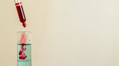 Kan ya da diğer kırmızı sıvılar cam pipetten test tüpüne, beyaz üzerinde izole.