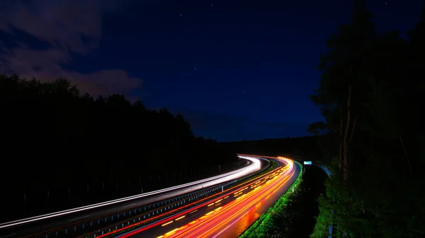 Gece lambaları. Geceleri hareket halindeki arabaların ışıkları. uzun pozlama