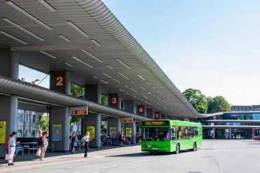 Merkezi bina ve platformları olan otobüs durağı