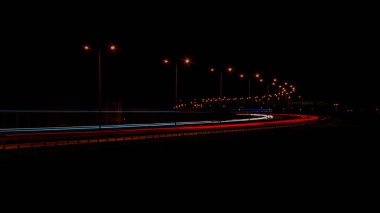 Gece lambaları. Geceleri hareket halindeki arabaların ışıkları. Uzun pozlama kırmızı, mavi, yeşil