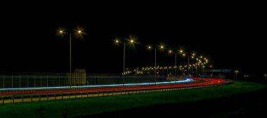 Gece lambaları. Geceleri hareket halindeki arabaların ışıkları. Uzun pozlama kırmızı, mavi, yeşil