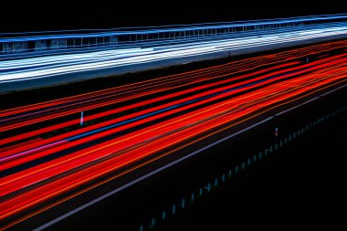 Gece lambaları. Geceleri hareket halindeki arabaların ışıkları. Uzun pozlama kırmızı, mavi, yeşil