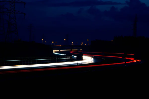 ไฟถนนกลางค ไฟของรถเคล อนท ในเวลากลางค แดง — ภาพถ่ายสต็อก