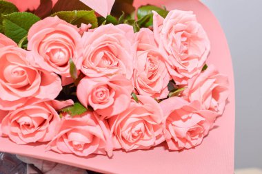 Beyaz arka planda vazoda güzel pembe güller